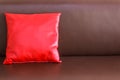 One red pillow on the brown leather sofa Royalty Free Stock Photo