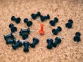 One red pin in the middle of black ones on a cork board Royalty Free Stock Photo