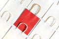 One red shopping bag in background of white bags isolated on white background. Royalty Free Stock Photo