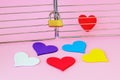 One red silk heart is in a cage locked with padlock. Five multicolored hearts are outside. To find the true love among people and Royalty Free Stock Photo