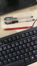 Red and black pens with keyboard Royalty Free Stock Photo