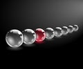 One red unique sphere came forward from a row of black spheres Royalty Free Stock Photo