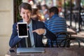 One relaxed young handsome professional businessman working with his laptop, phone and tablet in a noisy cafe.