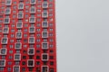 residential multi-storey building of red-white color against a gray sky
