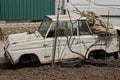 One retro disassembled white car stands on the gray ground