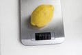 One ripe lemon is weighed on a kitchen scale. Diet Royalty Free Stock Photo