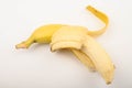 One ripe yellow partially peeled banana on a white background. Close up. Royalty Free Stock Photo