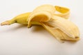 One ripe yellow partially peeled banana on a white background. Close up Royalty Free Stock Photo