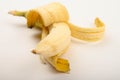 One ripe yellow partially peeled banana on a white background. Close up Royalty Free Stock Photo