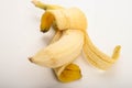 One ripe yellow partially peeled banana on a white background. Close up Royalty Free Stock Photo