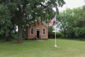 One Room Schoolhouse with Large Oak Tree and Flag