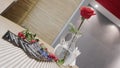 One rose stands on the table in a glass vase with an invitation card next to it. Media. A lonely flower decorates the