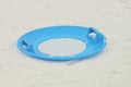 One round blue plastic sled plate lies on a snowdrift Royalty Free Stock Photo