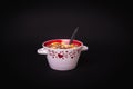 Round bowl with colorful cornflakes and milk and a spoon isolated on black Royalty Free Stock Photo