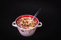 Round bowl with colorful cornflakes and milk and a spoon isolated on black Royalty Free Stock Photo