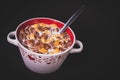 Round bowl with colorful cornflakes and milk and a spoon isolated on black Royalty Free Stock Photo