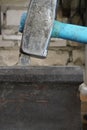 A one-ruble coin between a hammer and an anvil, against a brick wall. Strong ruble