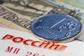 One ruble coin `ruble` written in Russian on the coin and banknote detail with the word `Russia` written in red