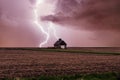 One rural barn, house in the middle in field on stormy sky with lightning strike background. Royalty Free Stock Photo