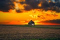 One rural barn in the middle of field landscape on the sunset and the stormy sky Royalty Free Stock Photo