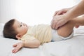 A small cute little baby girl was lying down, her diaper was being changed by her dad Royalty Free Stock Photo