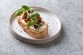 One sandwich with fresh radish microgreens and sun-dried tomatoes on grey. Close up Royalty Free Stock Photo