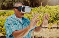 One senior mixed race farmer using a virtual reality headset through metaverse. Hispanic elderly man touching augmented