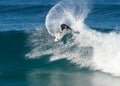 A male surfer executing a slashing backside top-turn off-the-lip at Iluka`s North Wall.