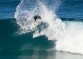 A male surfer executing a slashing backside top-turn off-the-lip at Iluka`s North Wall.