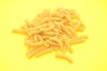 One serving of raw fusilli pasta on yellow background. Classic Variety of pasta Royalty Free Stock Photo