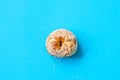 One sesame seeded bagel on a blue background. Top view