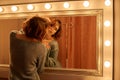 One girl with flowing brown hair in a knitted sweater passion posing near mirror with, fashion photo