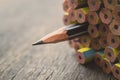 One sharpened pencil standing out from the other new pencil on w Royalty Free Stock Photo