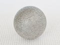 One shiny silver christmas ball with sparkles on a white textural background Royalty Free Stock Photo