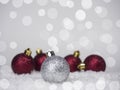 One silver ball on the Christmas tree and four red balls in the back, on a bokeh background Royalty Free Stock Photo