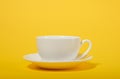 One simple coffee cup on yellow color background, closeup photo