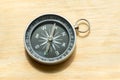 One simple small compass, wayfinding symbol world directions abstract concept, object closeup, natural sun light, laying on a