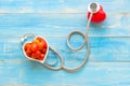 One single alone red heart love shape hand exercise ball with bandage MD medical doctor physician`s stethoscope blue wood backgrou