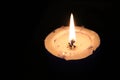 One single big burning candle on a black background Royalty Free Stock Photo