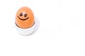 One single brown egg with positive face smiling in an egg stand on white backdrop. Drawn black smile