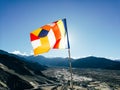 One single Buddhist prayer flag in six colors fluttering in mountain region against the sunlight Royalty Free Stock Photo