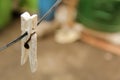 One single dirty white plastic peg hanging on a wire