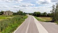 One single empty Polish road aerial view, no cars, calm rural area neighborhood, houses around, Eastern Europe countryside scenery