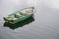 One single green rustic wooden boat alone in sea water Royalty Free Stock Photo