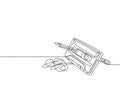 One single line drawing of tangled analog cassette tape ribbon rotate by wooden pencil. Vintage musical item concept continuous