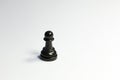 One single lone black pawn chess piece on sad dark white grey background. Loneliness, being alone, abandoned, depression Royalty Free Stock Photo