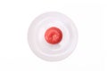 One single red ripe fresh raw tomato on white ceramic plate isolated on white, mediterranean diet concept Royalty Free Stock Photo