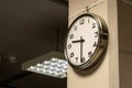 One single simple industrial clock in a factory hall or a corporate office on the wall. Working 9 to 5, clocking in and out, time