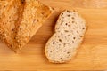 One slice of bread is sliced from a loaf of whole grain bread on a cutting board. The concept of eating alone. Simple wholesome Royalty Free Stock Photo