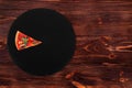 One slice of delicious pizza with spicy salami, arugula, tomatoes, mushrooms and texas spice mix, on a slate black platter Royalty Free Stock Photo